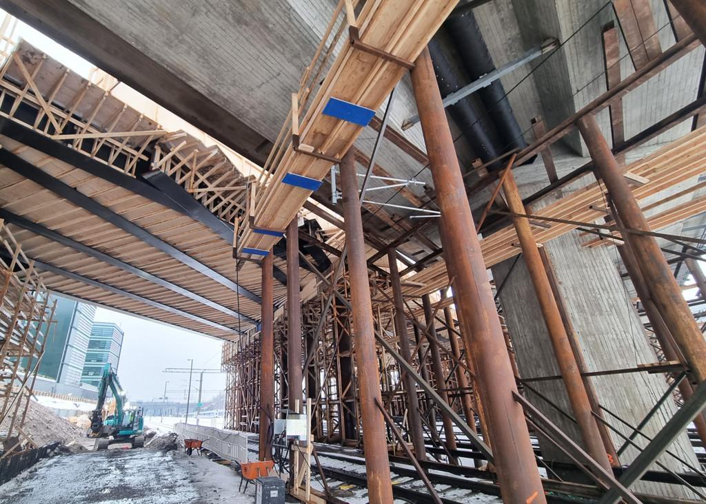 Työtasojen avulla Kreaten sillanrakentajat voivat tehdä töitä 25 kV jännitteisten ajolankojen päällä katkaisematta Veturitien sillan alapuolella kulkevaa junaliikennettä.