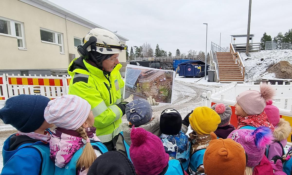 Kreaten työmaapäällikkö Aki Putto kertoi päiväkodin lapsille kierroksen aluksi koneista ja työvaiheista kuvien kera.