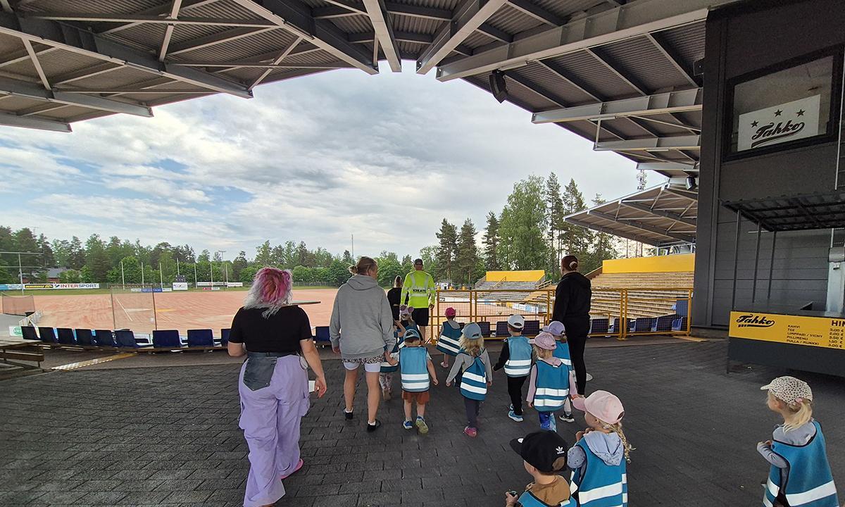 Päiväkodista tulleet vierailijat matkalla Pihkalan stadionin uudelta tasanteelta kohti kenttää. 