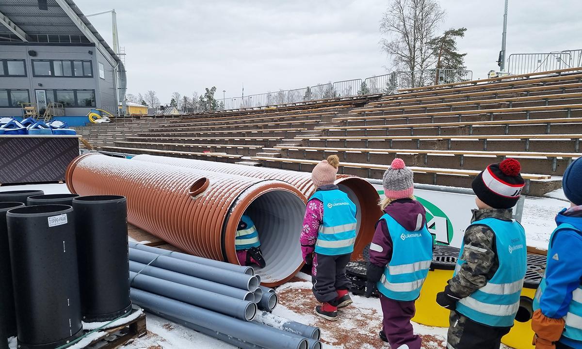 Päiväkodin lasten tutustumiskierros eteni työmaalla olevien viivytysputkien kautta eteenpäin.